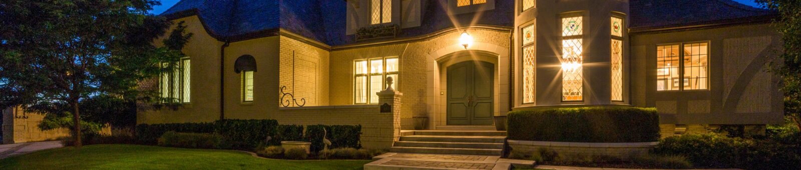 A larger single-family home lit up at night.