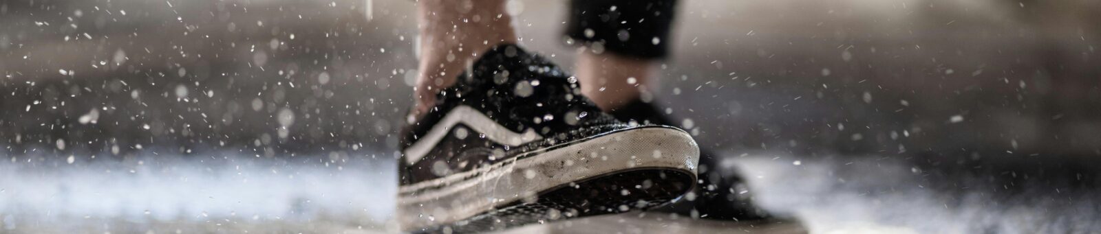 Someone's legs walking in the rain with the ground wet