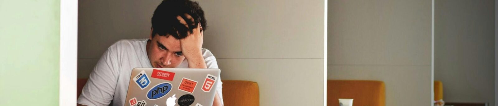 a young man on a laptop who is stressed out