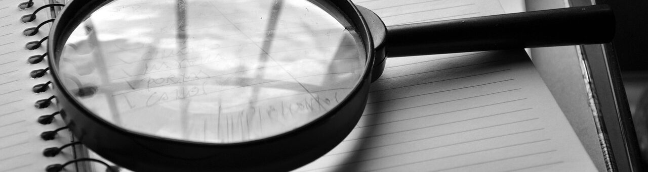 A magnifying glass reviewing a business security audit