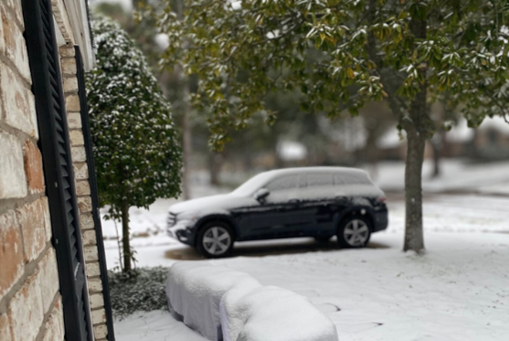 A snowy house and car during winter storm
