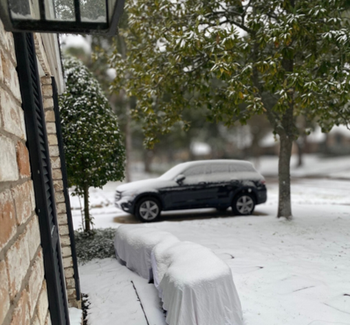A snowy house and car during winter storm