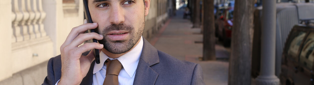 A man is suspicious of insider security risks while on the phone outdoors