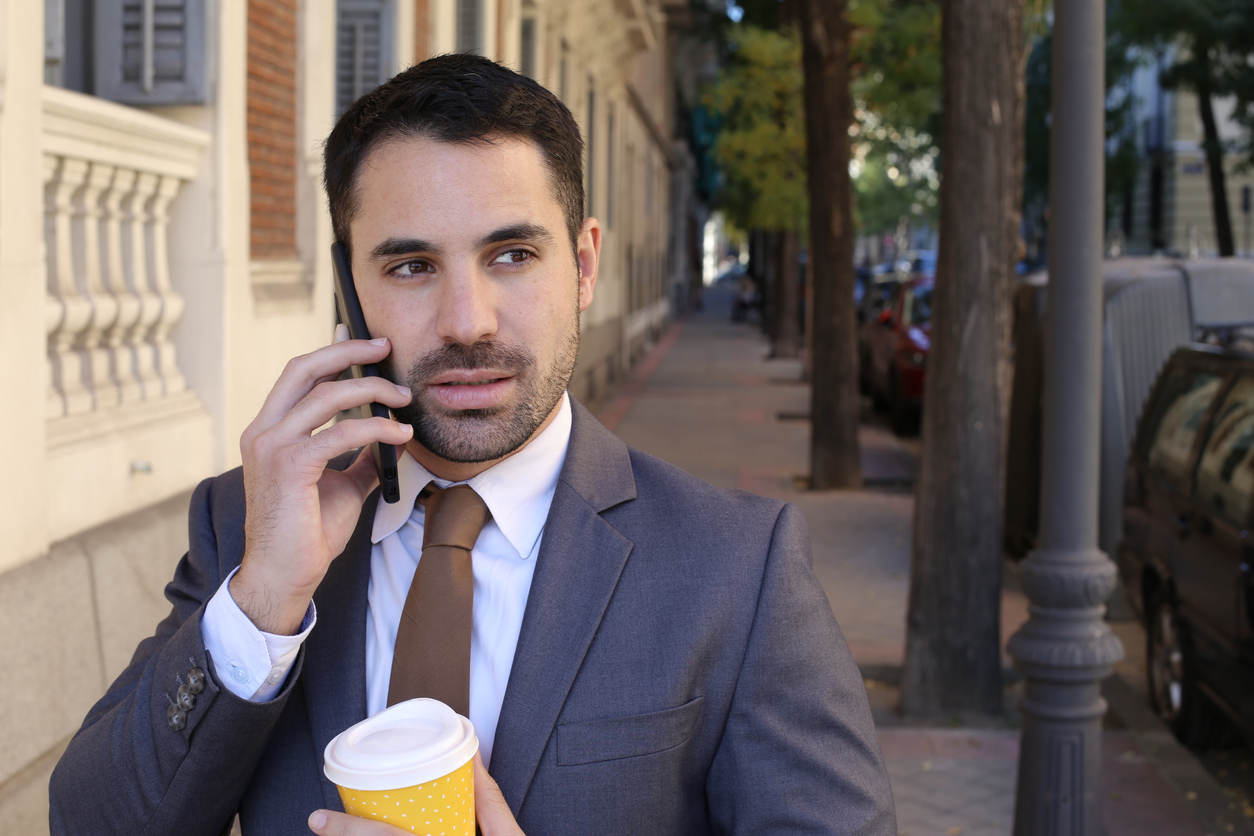 A man is suspicious of insider security risks while on the phone outdoors