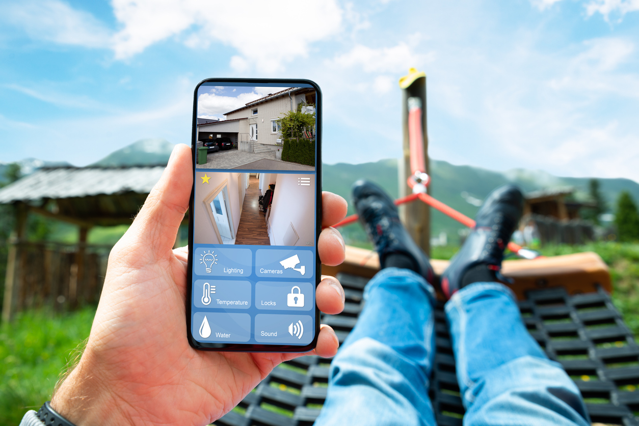 A man uses smart security settings, cameras, lighting, and remote monitoring to protect your home and enjoy greater peace of mind while on vacation.
